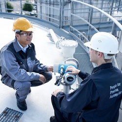 タンクの上で機器を点検するお客様とEndress+Hauser社員