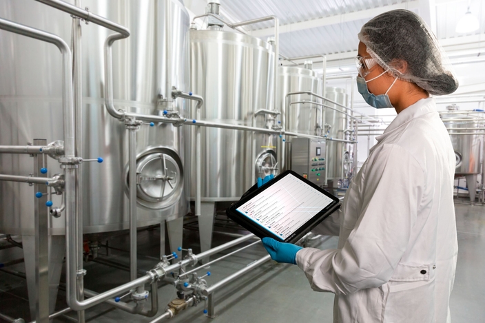 食品・飲料製造設備で、Netilion Asset Healthの状態を確認する女性